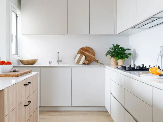 Cocinas modernas con encimeras blancas, armarios minimalistas y detalles en madera. Perfectas para un hogar contemporáneo.