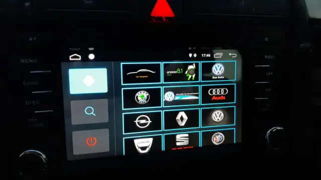 Ekran multimedialny z ikonami marek samochodów i opcją android auto ustawienia.