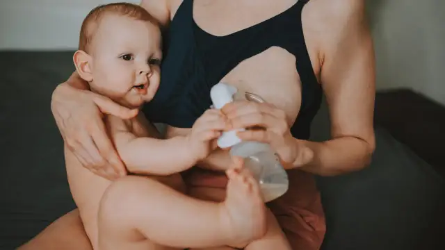 Mama karmi piersią i odciąga pokarm, pokazując, jak karmienie piersią a praca mogą iść w parze.