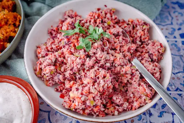 Bunter Karottensalat, frisch zubereitet im Thermomix, garniert mit Petersilie. Daneben eine Schale mit cremiger Sauce.