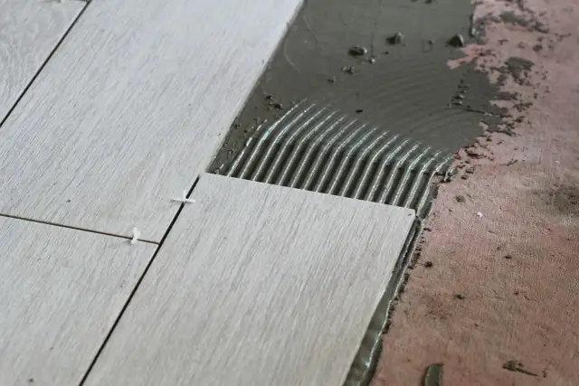 Układanie płytek 60x60 cennik. Nowe płytki na kleju, widoczne krzyżyki dystansowe.
