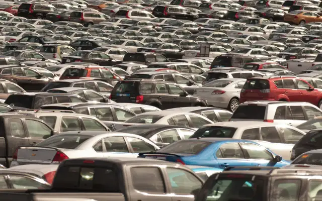 Ogromny parking pełen nowych sedanów i innych samochodów.