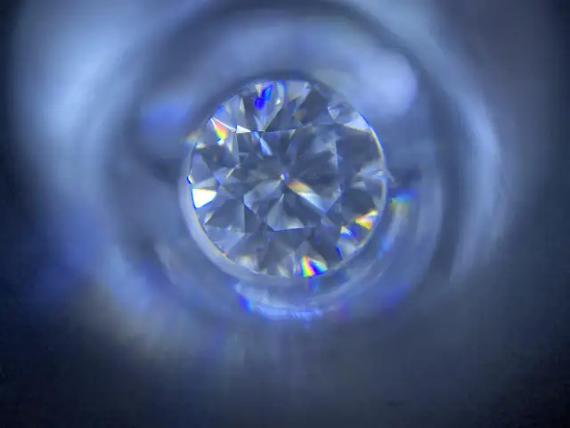 Błyszczący moissanit, co to jest? Kamień o tęczowych refleksach, przypominający diament, widziany z bliska.