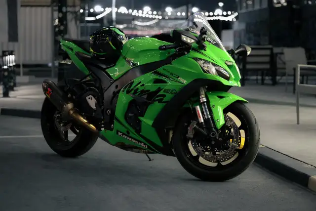 Japoński motocykl Kawasaki Ninja ZX-10R w jaskrawym zielonym kolorze, gotowy do nocnej jazdy.