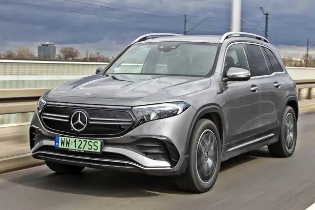 Szary Mercedes EQB jedzie po moście.