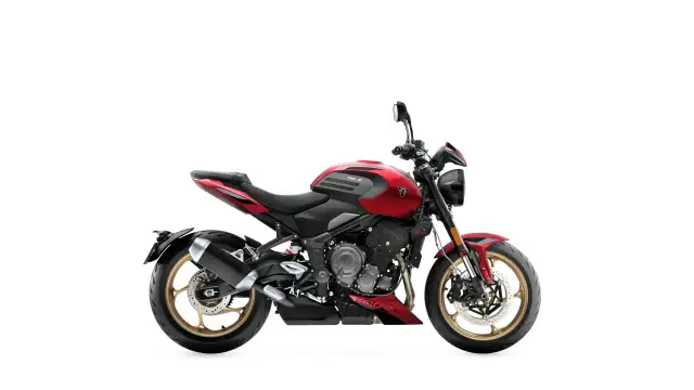 Czerwony motocykl Triumph Trident 660, jeden z najmocniejszych motocykli w swojej klasie, z czarnymi akcentami i złotymi felgami.