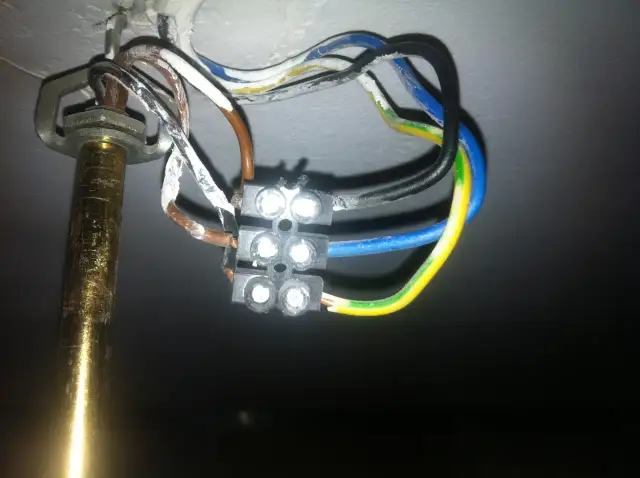 Widok z bliska na połączenie przewodów elektrycznych żyrandola z kostką.