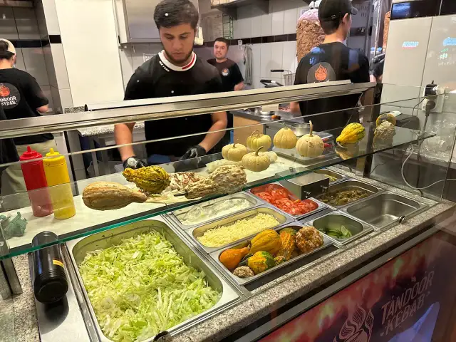 Kebab w Polsce: witryna z dodatkami, warzywami i ozdobnymi dyniami.