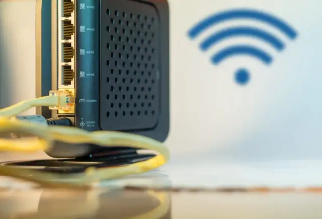 Czarny router z wieloma portami LAN i ikoną Wi-Fi. Ten wzmacniacz internetu zapewnia stabilne połączenie.