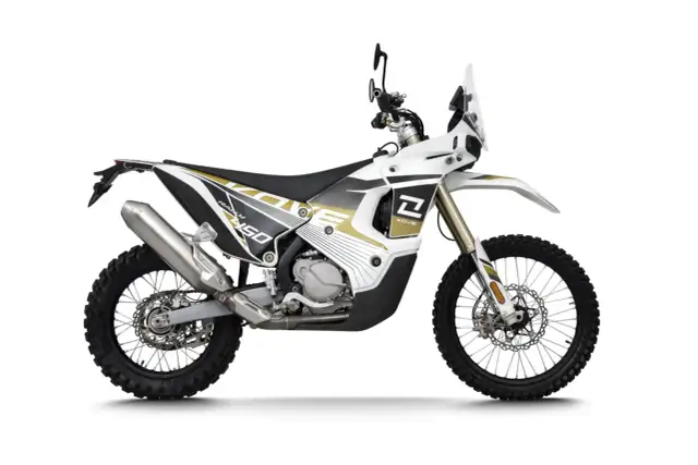 Biały motocykl Kove 450 Rally z czarnymi i złotymi akcentami, gotowy na przygodę.