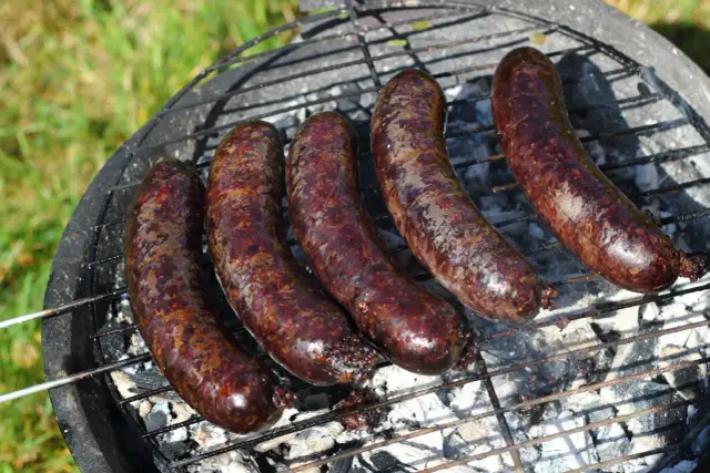 Pięć soczystych kaszanek z grilla, rumieniących się na ruszcie nad żarem. Idealne na letnie popołudnie.