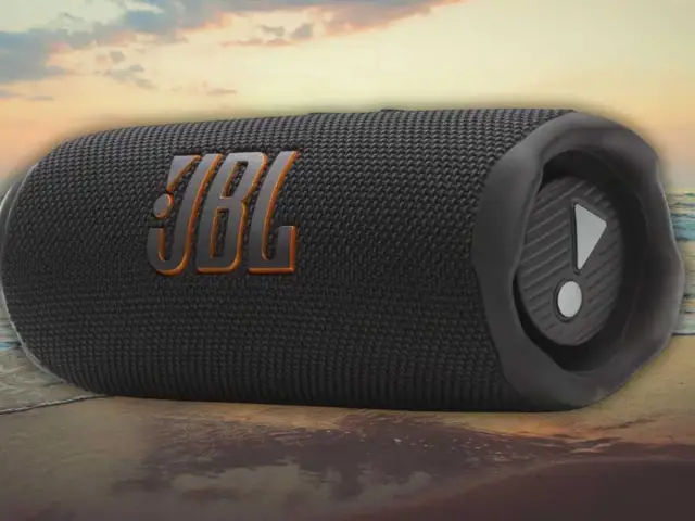 Enceinte JBL noire sur une plage. Découvrez comment fonctionne une enceinte JBL pour une expérience sonore immersive, même en extérieur.