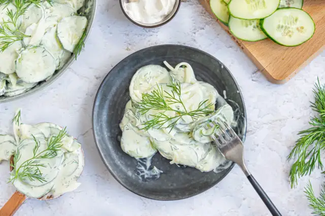 Cremiger Gurkensalat mit Schmand und frischem Dill, garniert mit Dillzweigen. Ein erfrischender Genuss!