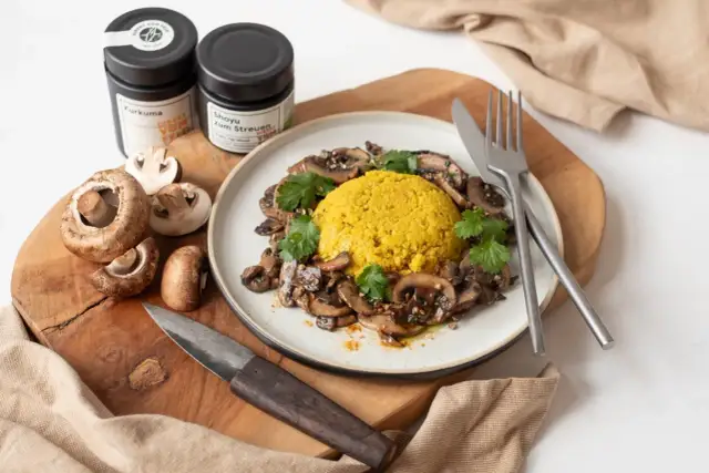 Veganes Pilzgericht mit gelbem Reis, garniert mit Koriander. Perfekt für Pilz Rezepte vegan.