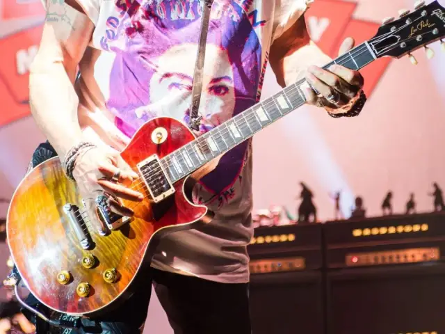 Muzyk gra na gitarze Gibson Les Paul, tworząc dźwięki, które mogłyby znaleźć się na najważniejszych płytach w historii muzyki.