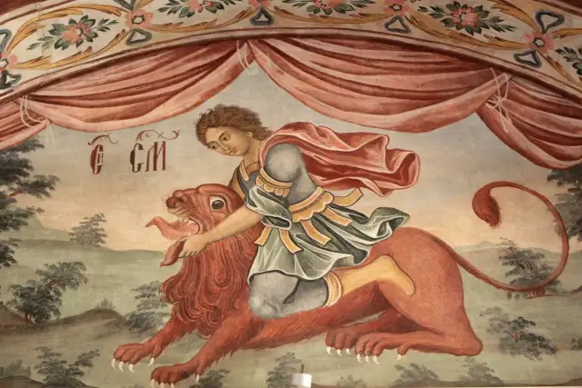 Młody Samson z biblii walczy z lwem, którego rozrywa gołymi rękami. Fresk przedstawia biblijną opowieść o Samsonie.