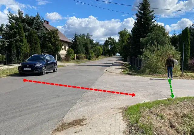 Czerwona linia pokazuje, jak zatrzymać samochód przed skrzyżowaniem. Zielona strzałka wskazuje miejsce, gdzie stoi człowiek.