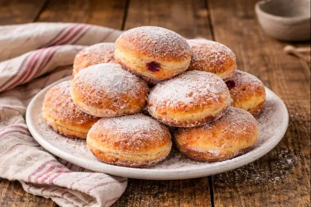 Ein Haufen frisch gebackener Berliner, bestäubt mit Puderzucker. Dieses berliner rezept ist ein Genuss für jeden Kaffeetisch.