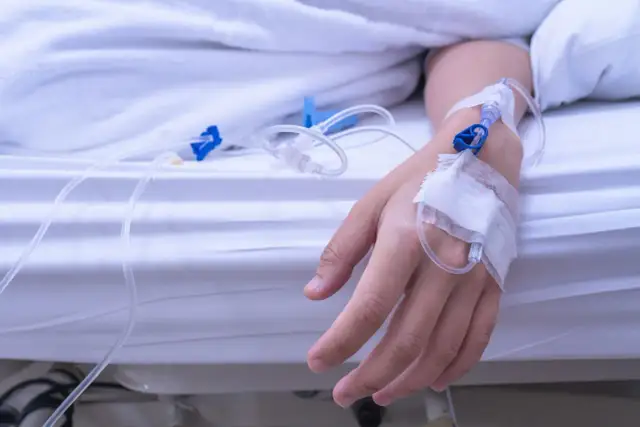 Ręka pacjenta z wenflonem, podłączona do kroplówki. Leczenie hipernatremii.