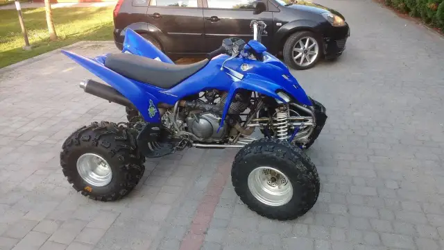 Niebieski Yamaha Raptor 350, quad z mocnym silnikiem, gotowy do jazdy. Ile ma koni? To pytanie dla fanów off-roadu!
