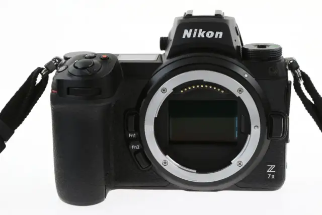 Czarny aparat Nikon Z7 III z obiektywem bez obiektywu, widoczny z przodu, z paskiem na nadgarstek.