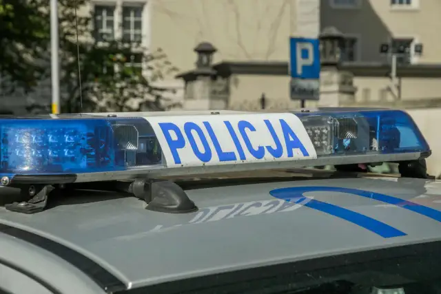 Niebieskie światła policyjne i napis "POLICJA" na dachu radiowozu. Uważaj na przegląd, bo czeka mandat za brak przeglądu.