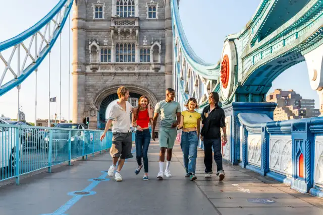Grupa przyjaciół cieszy się londyńskim **city break** na Tower Bridge.