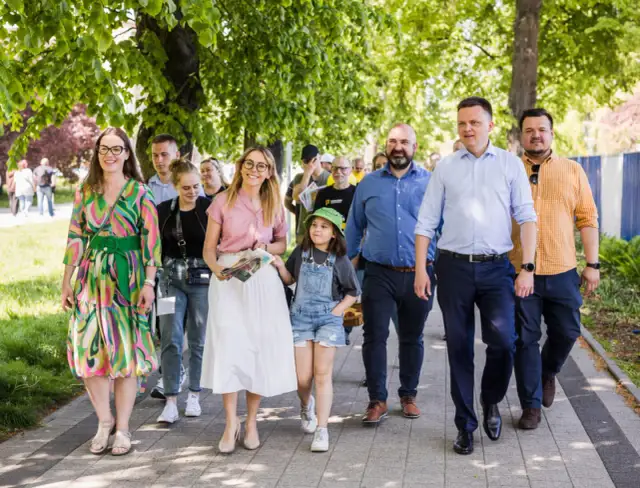 Grupa osób idzie chodnikiem. Wśród nich liderzy Polski 2050, którzy realizują obietnice wyborcze.