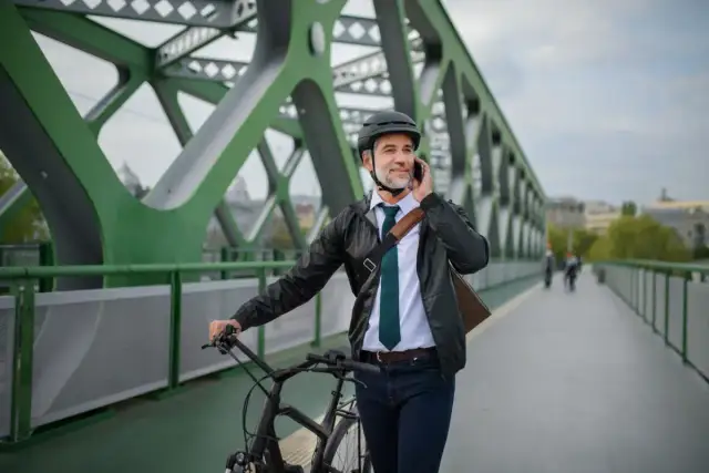 Biznesmen na rowerze rozmawia przez telefon, zastanawiając się nad zakupem roweru na firmę a VAT.
