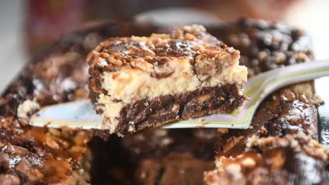 Ein Stück Schoko-Käsekuchen mit Walnüssen, der so gut aussieht, dass man ihn "friss dich dumm" nennen könnte.