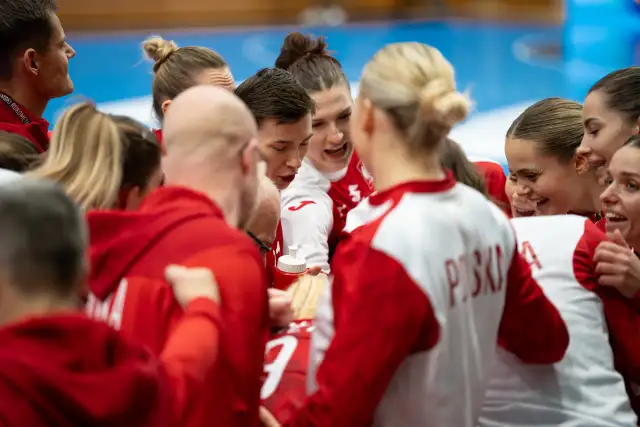 Drużyna piłki ręcznej w czerwonych strojach, zjednoczona przed meczem. Emocje i determinacja na twarzach zawodniczek podczas mistrzostw świata.