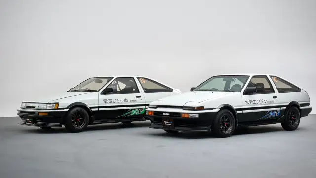Dwa białe coupe ae86: jeden z napędem elektrycznym (EV), drugi z silnikiem wodorowym (H2).