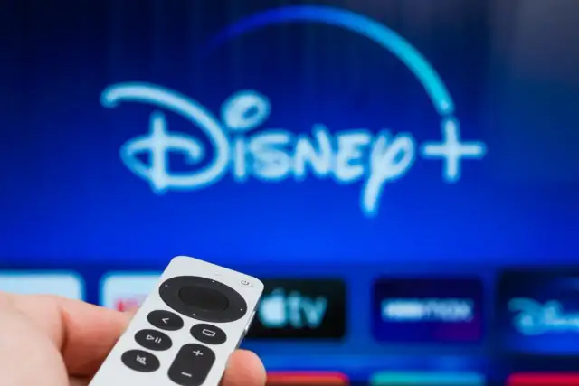 Pilot w dłoni, ekran z logo Disney+. Dowiedz się, jak dodać aplikacje do telewizora LG, by cieszyć się ulubionymi treściami.