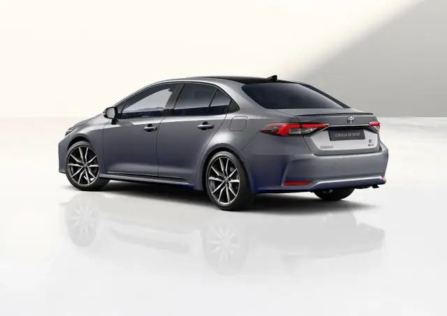 Szary sedan Toyota Corolla GR Sport z czarnym dachem i sportowymi felgami, prezentujący dynamiczną sylwetkę.