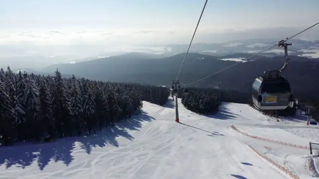 Widok z kolejki linowej na ośnieżony stok narciarski. Sprawdź jańskie łaźnie ski cennik i zaplanuj swój wyjazd!