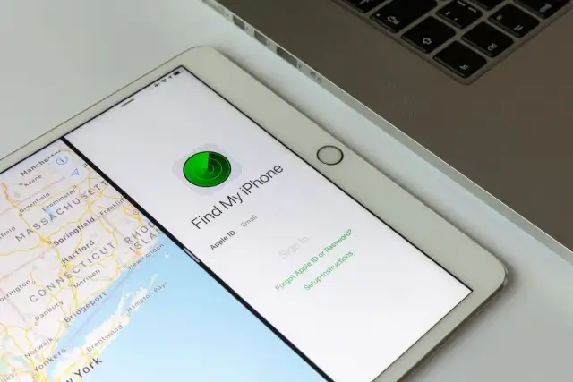 Tablet z mapą i aplikacją "Find My iPhone" do lokalizacji telefonu. Obok klawiatura laptopa.