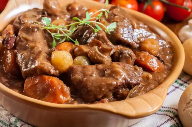 Aksamitna wołowina w sosie z pieczarkami i cebulką, udekorowana gałązką tymianku. Idealna na chłodne dni.