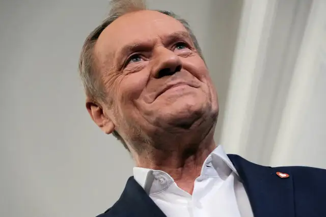 Uśmiechnięty Donald Tusk, jak polityka rządu Tuska wpływa na giełdę i rynek kapitałowy.