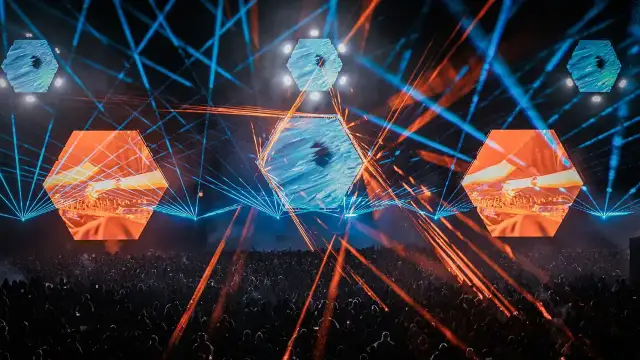 Koncertowa noc na festiwalu **Audioriver**. Tłum bawi się w rytm muzyki, a nad głowami wirują laserowe wiązki i sześciokątne ekrany z wizualizacjami.