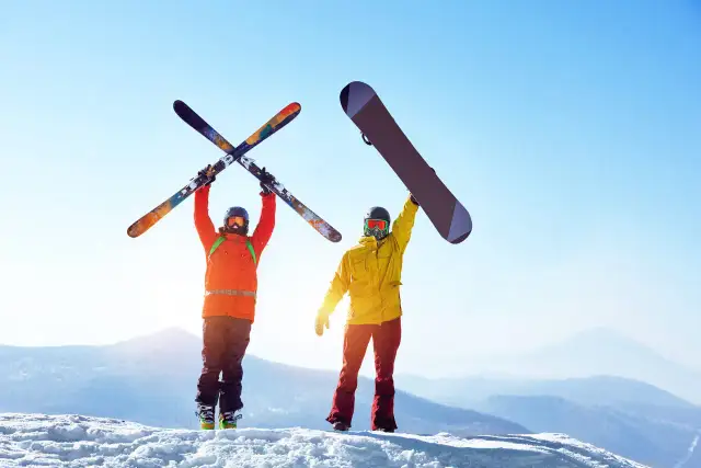 Narciarz i snowboardzista na szczycie góry. Co jest bardziej kontuzyjne narty czy snowboard?
