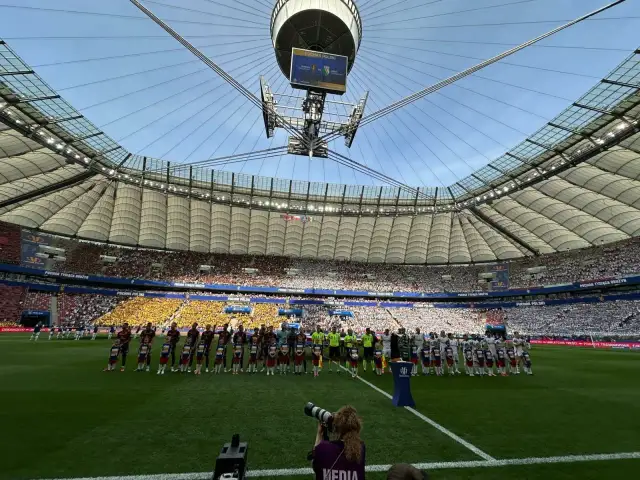 Piłkarze i dzieci stoją na murawie stadionu przed meczem Pucharu Polski.