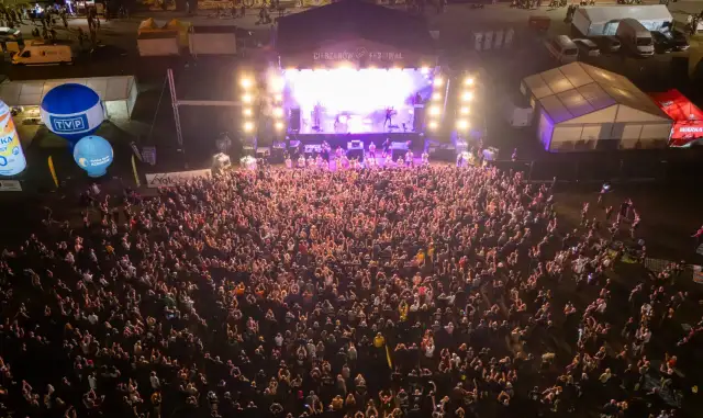 Tłum ludzi na koncercie podczas Cieszynów Rock Festiwal. Na scenie gra zespół, a przed nią tysiące fanów.