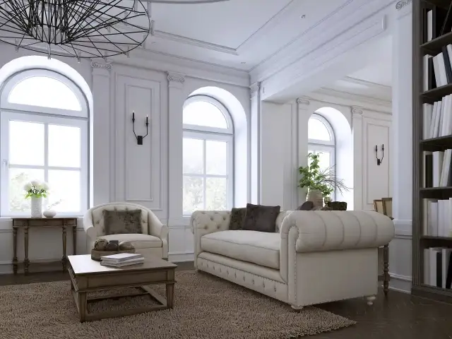 Elegancki salon z sofą, fotelem i książkami na półce.