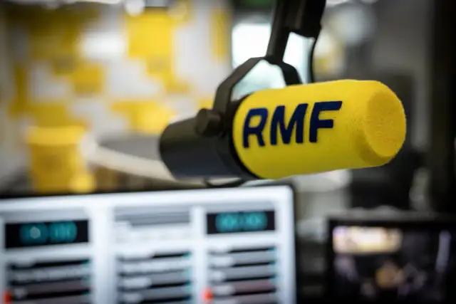 Mikrofon studyjny RMF z żółtym futerkiem i niebieskim logo.