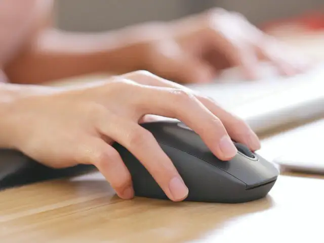 Dłoń steruje myszką bezprzewodową. Dowiedz się, jak podłączyć myszkę bezprzewodową do laptopa bez USB, korzystając z Bluetooth.