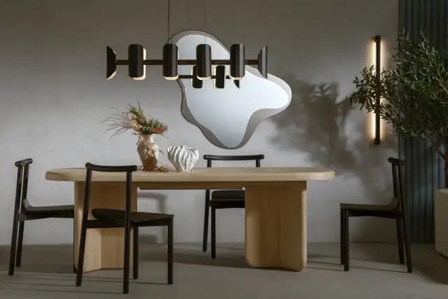 Nowoczesna jadalnia z drewnianym stołem, czarnymi krzesłami i designerską lampą. Ile lamp nad stołem w jadalni? Jedna wisząca.