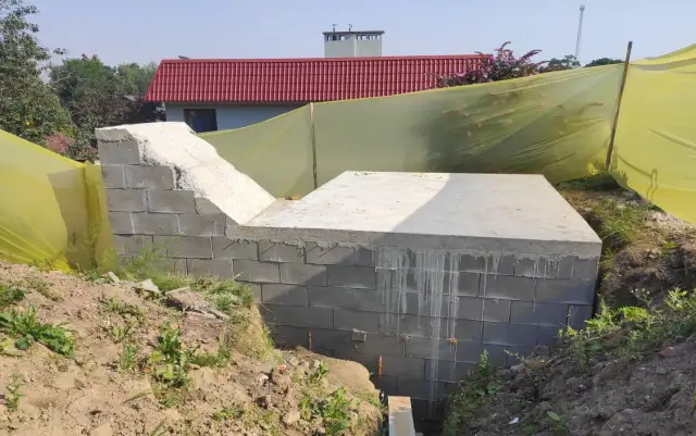 Budowa ziemianki: betonowy fundament i ściany z bloczków, gotowe do dalszych prac.