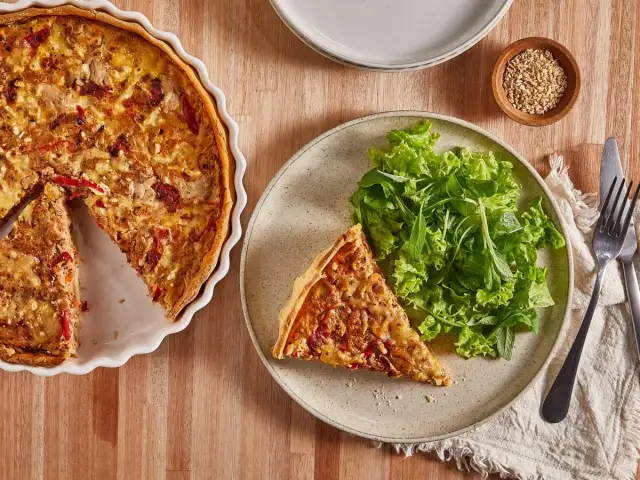 Tarta de atún dorada, servida con ensalada fresca. Un plato perfecto para disfrutar.