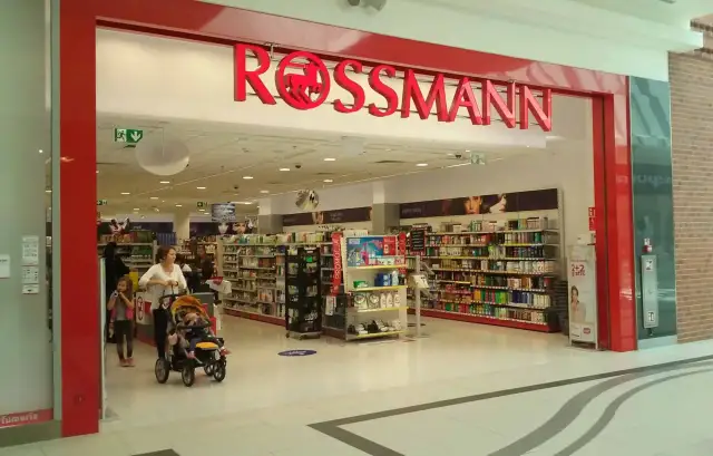 W Rossmannie, gdzie można zrobić wywołanie zdjęć z kliszy, matka z dziećmi robi zakupy.