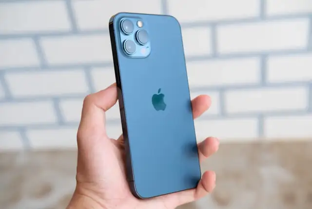 Main bleue, triple appareil photo, logo Apple. Les iphone 12 spécifications techniques sont impressionnantes.